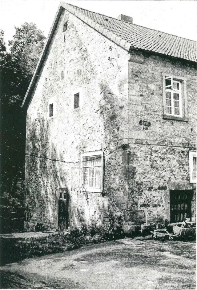 Old black-and-white photo: the rubble-stone mill house with its steep tiled roof